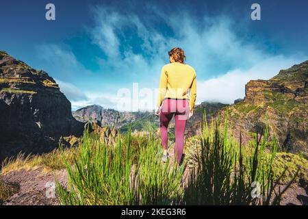 Description: Femme appréciant le paysage de montagne de point de vue très pittoresque le long de la randonnée à Pico Ruivo dans la matinée. Pico do Arieiro, île de Madère Banque D'Images