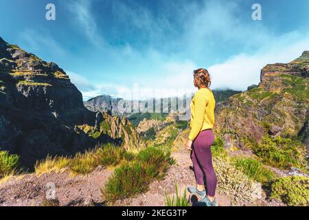 Description: Femme appréciant le paysage de montagne de point de vue très pittoresque le long de la randonnée à Pico Ruivo dans la matinée. Pico do Arieiro, île de Madère Banque D'Images