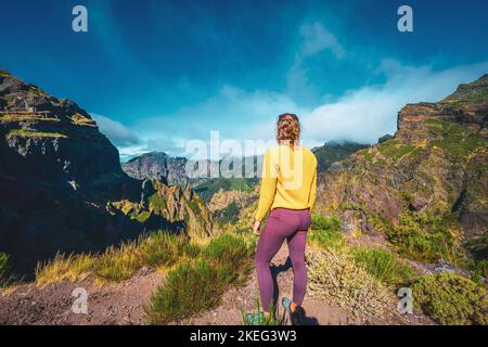 Description: Femme appréciant le paysage de montagne de point de vue très pittoresque le long de la randonnée à Pico Ruivo dans la matinée. Pico do Arieiro, île de Madère Banque D'Images