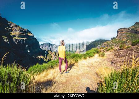 Description: Femme appréciant le paysage de montagne de point de vue très pittoresque le long de la randonnée à Pico Ruivo dans la matinée. Pico do Arieiro, île de Madère Banque D'Images