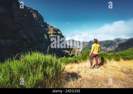 Description: Femme appréciant le paysage de montagne de point de vue très pittoresque le long de la randonnée à Pico Ruivo dans la matinée. Pico do Arieiro, île de Madère Banque D'Images