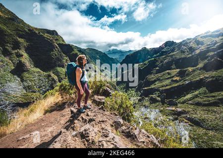 Description: Femme appréciant le paysage de montagne de point de vue très pittoresque le long de la randonnée à Pico Ruivo à midi. Pico do Arieiro, Île de Madère, Port Banque D'Images