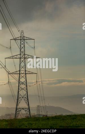 Pylônes sur une colline de Pennine à l'aube près de Halifax, West Yorkshire, Royaume-Uni. Les pylônes – également connues sous le nom de tours de transmission d’électricité – sont les soutiens structurels qui ont transporté le réseau britannique de lignes aériennes haute tension depuis près de 100 ans. Aujourd'hui, il y a plus de 90 000 pylônes d'électricité à travers la Grande-Bretagne, couvrant 4 300 milles de route (7 000 kilomètres). Banque D'Images