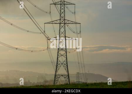 Pylônes sur une colline de Pennine à l'aube près de Halifax, West Yorkshire, Royaume-Uni. Les pylônes – également connues sous le nom de tours de transmission d’électricité – sont les soutiens structurels qui ont transporté le réseau britannique de lignes aériennes haute tension depuis près de 100 ans. Aujourd'hui, il y a plus de 90 000 pylônes d'électricité à travers la Grande-Bretagne, couvrant 4 300 milles de route (7 000 kilomètres). Banque D'Images