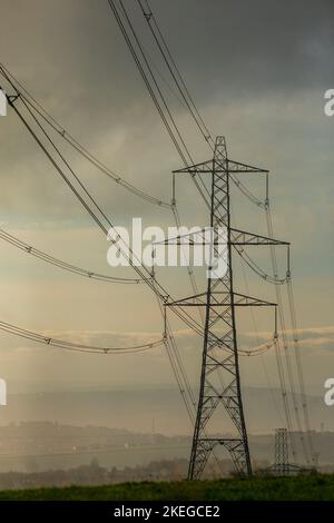 Pylônes sur une colline de Pennine à l'aube près de Halifax, West Yorkshire, Royaume-Uni. Les pylônes – également connues sous le nom de tours de transmission d’électricité – sont les soutiens structurels qui ont transporté le réseau britannique de lignes aériennes haute tension depuis près de 100 ans. Aujourd'hui, il y a plus de 90 000 pylônes d'électricité à travers la Grande-Bretagne, couvrant 4 300 milles de route (7 000 kilomètres). Banque D'Images