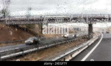 Vue à travers le pare-brise de la circulation sur l'autoroute en pluie Banque D'Images