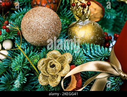 Décorations de Noël, composition festive avec branches de pin naturelles, boules, ruban et boules. Magnifique décoration artisanale de luxe en gros plan. Banque D'Images