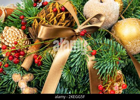 Décorations de Noël, composition festive avec branches et cônes de pin naturel, ruban et boules. Magnifique décoration artisanale de luxe proche- Banque D'Images