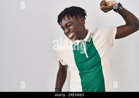 Homme africain avec des dreadlocks debout sur un arrière-plan isolé s'étirant, fatigué et détendu, endormi et bâillonne pour tôt le matin Banque D'Images