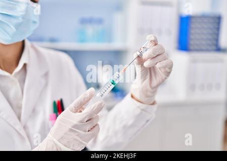 Jeune scientifique tenant un vaccin covid en laboratoire Banque D'Images
