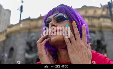 Dragqueen se balade en ville en écoutant de la musique avec sa tasse à café Banque D'Images