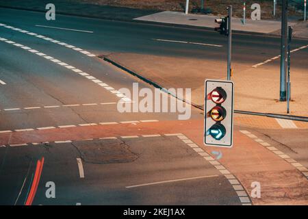 Vue aérienne de l'intersection de nuit avec feu de circulation, traces de voitures et de cyclistes sur la piste cyclable Banque D'Images