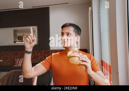 Un client mécontent d'un restaurant de restauration rapide se retrouve dans un hamburger et a trouvé un produit gâté lors de son déjeuner Banque D'Images