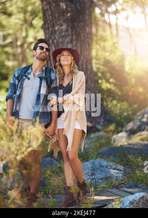 Satisfait du paysage. Prise de vue en longueur d'un jeune couple affectueux lors d'une randonnée. Banque D'Images