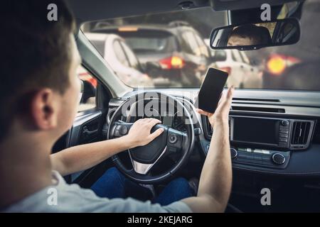 Un conducteur furieux a fait retentir l'avertisseur sonore en colère contre l'embouteillage. Un homme agressif qui ne conduit pas avec sécurité lorsqu'il utilise son téléphone devant la direction W Banque D'Images