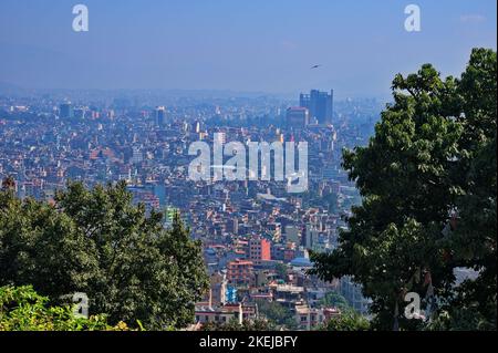 Vue panoramique de Katmandou au Népal à travers les branches d'arbres Banque D'Images