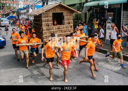 Pasig City, Philippines. 12th novembre 2022. Les résidents courent en portant une hutte faite de palmier nipa pendant la course Buhat Kubo (portant la hutte nipa) à Pasig City, aux Philippines, le 12 novembre 2022. Crédit: Rouelle Umali/Xinhua/Alamy Live News Banque D'Images