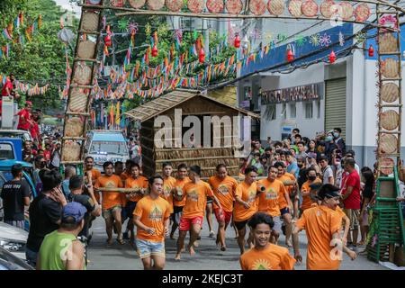 Pasig City, Philippines. 12th novembre 2022. Les résidents courent en portant une hutte faite de palmier nipa pendant la course Buhat Kubo (portant la hutte nipa) à Pasig City, aux Philippines, le 12 novembre 2022. Crédit: Rouelle Umali/Xinhua/Alamy Live News Banque D'Images