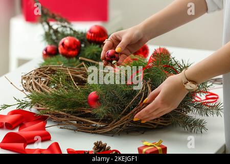 Femme faisant couronne de Noël à table, gros plan Banque D'Images