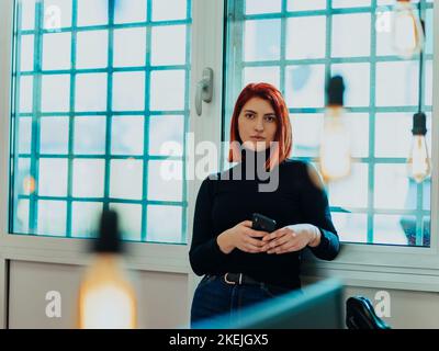 portrait d'une femme moderne au bureau la nuit près de la fenêtre Banque D'Images