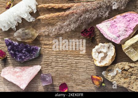 Pose à plat de plusieurs pierres précieuses et minéraux sur la table en bois avec l'espace de copie au milieu. Pierres de cristal curatif pour Wicca ou Reiki Witchcraf Banque D'Images