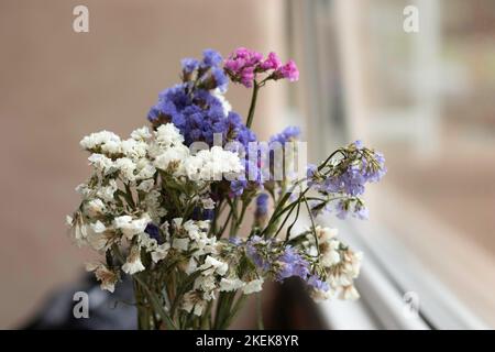 beau bouquet de petites fleurs près de la fenêtre, fleurs de différentes couleurs Banque D'Images