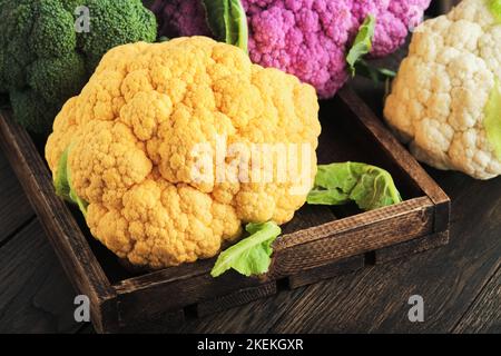 Chou-fleur de Colorfu. Diverses sortes de chou-fleur sur fond de bois ancien. Cabages de couleur violet, jaune, blanc et vert. Brocoli et romanesco. AGR Banque D'Images