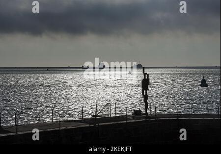 La sculpture « look II » 12ft de Sir Anthony Gormley donne sur le détroit de Plymouth depuis sa maison sur West Hoe Pier Plymouth. Dans la distance le brise-lames a Banque D'Images