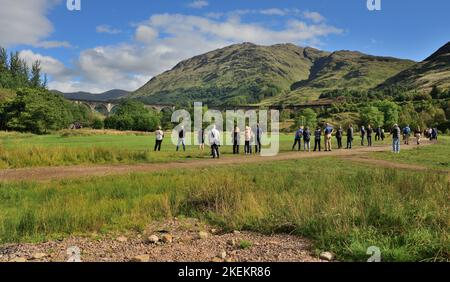 Les gens attendent de voir le train à vapeur Jacobite traversant le viaduc de Glenfinnan, en Écosse. Banque D'Images