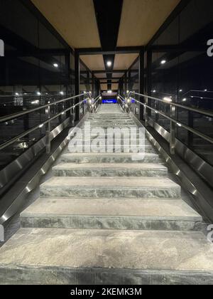 Photo d'un escalier moderne bien éclairé dans un tunnel de verre de la ville Banque D'Images