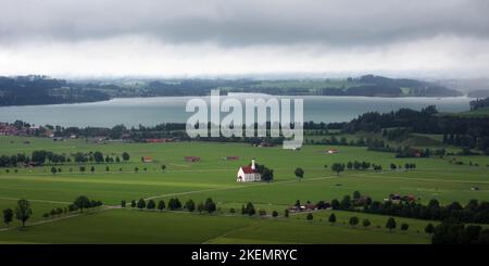 Eglise de Saint Coloman à Schwangau, près du château de Neuschwanstein à Fussen, célèbre monument de Bavière, Allemagne. Vue de loin avec Forggensee Banque D'Images