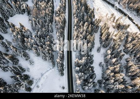 Vue aérienne du dessus de la route de montagne en hiver. Un hiver épique et enneigé dans les montagnes. Épinettes enneigées, forêt gelée. Banque D'Images