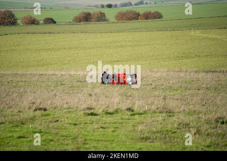 Un parachutiste rassemblant le parachute ayant atterri dans une prairie Banque D'Images