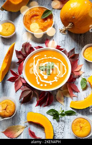 Soupe au potiron et muffins avec les feuilles d'automne sec blanc sur fond de bois Banque D'Images