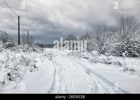 Rut profonde sur la route avec de la neige fraîche Banque D'Images