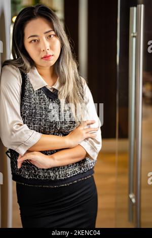 Une jeune scientifique de données féminine attend à la porte d'une salle de conférence Banque D'Images