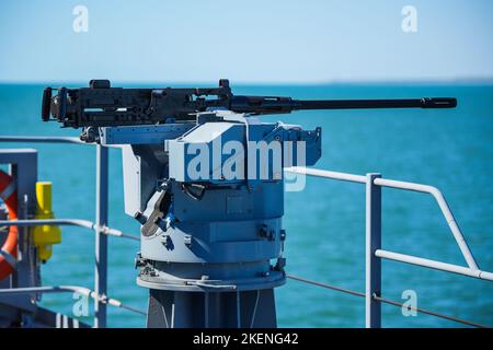 Image couleur d'une mitrailleuse automatique sur le pont d'un navire militaire, en mer. Banque D'Images