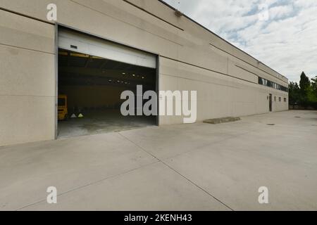 Façade de bâtiment industriel en ciment et mur en béton avec pont-levis métallique Banque D'Images