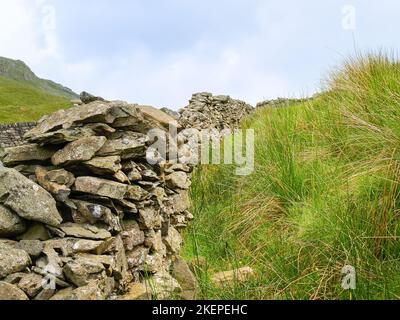 Mur de pierre sèche menant à la montée dans les terres agricoles Banque D'Images