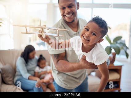 Papa, garçon et avion jouet dans le salon pour le jeu, le plaisir ou le collage tout en étant heureux ensemble. Père, fils et jouets d'avion avec le sourire à la maison avec amour Banque D'Images