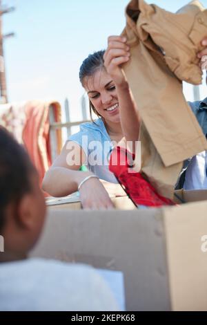 Trier les vêtements pour les enfants. Les travailleurs bénévoles distribuent des vêtements aux enfants défavorisés. Banque D'Images