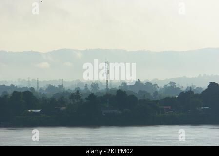 Paysage du Mékong avec bâtiments, infrastructure, téléphone cellulaire pylône et montagnes au Laos. Banque D'Images