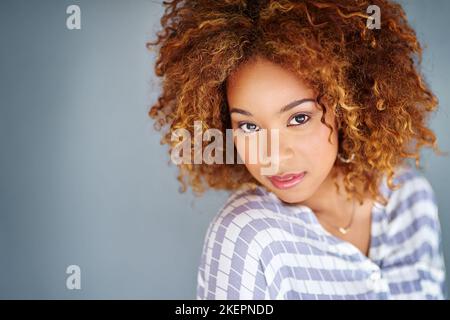 Pleine de confiance en soi. Photo en studio d'une jeune femme d'affaires sur fond gris. Banque D'Images