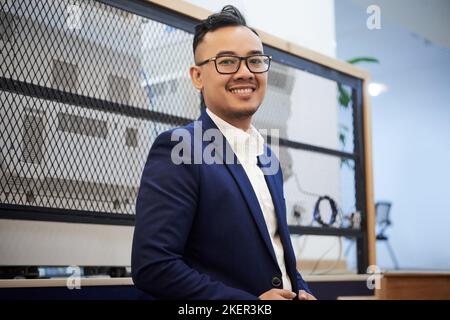 Portrait d'un beau et heureux jeune homme d'affaires dans son bureau Banque D'Images