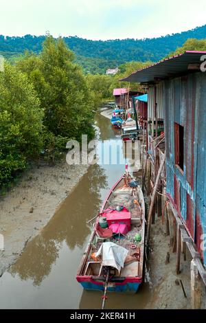 Village de pêcheurs en Asie. Bateaux près de maisons en ruine sur pilotis. Banque D'Images