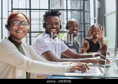 Équipe afro-américaine travaillant au bureau du centre d'appels pour aider les personnes avec l'aide de télémarketing Banque D'Images