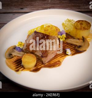 Recette de veau, confit de pomme de terre, champignons, purée de carottes, sauce au vinaigre balsamique, miel et veau Banque D'Images