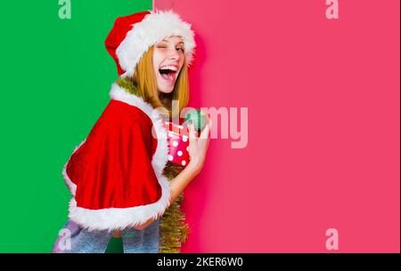 Drôle de femme Winkingh avec boule de noël. Jolie dame fête les vacances d'hiver tenir des boules de noël sur un fond isolé jeune belle fille avec Banque D'Images