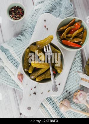 Conserver les concombres marinés, le poivre, les assaisonnements et l'ail sur une table en bois blanc. Aliments fermentés sains. Légumes en conserve à la maison. Banque D'Images