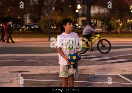 6 novembre 2022. Cangas, Pontevedra, Espagne. Enfant jouant avec un ballon dans une aire de jeux Banque D'Images